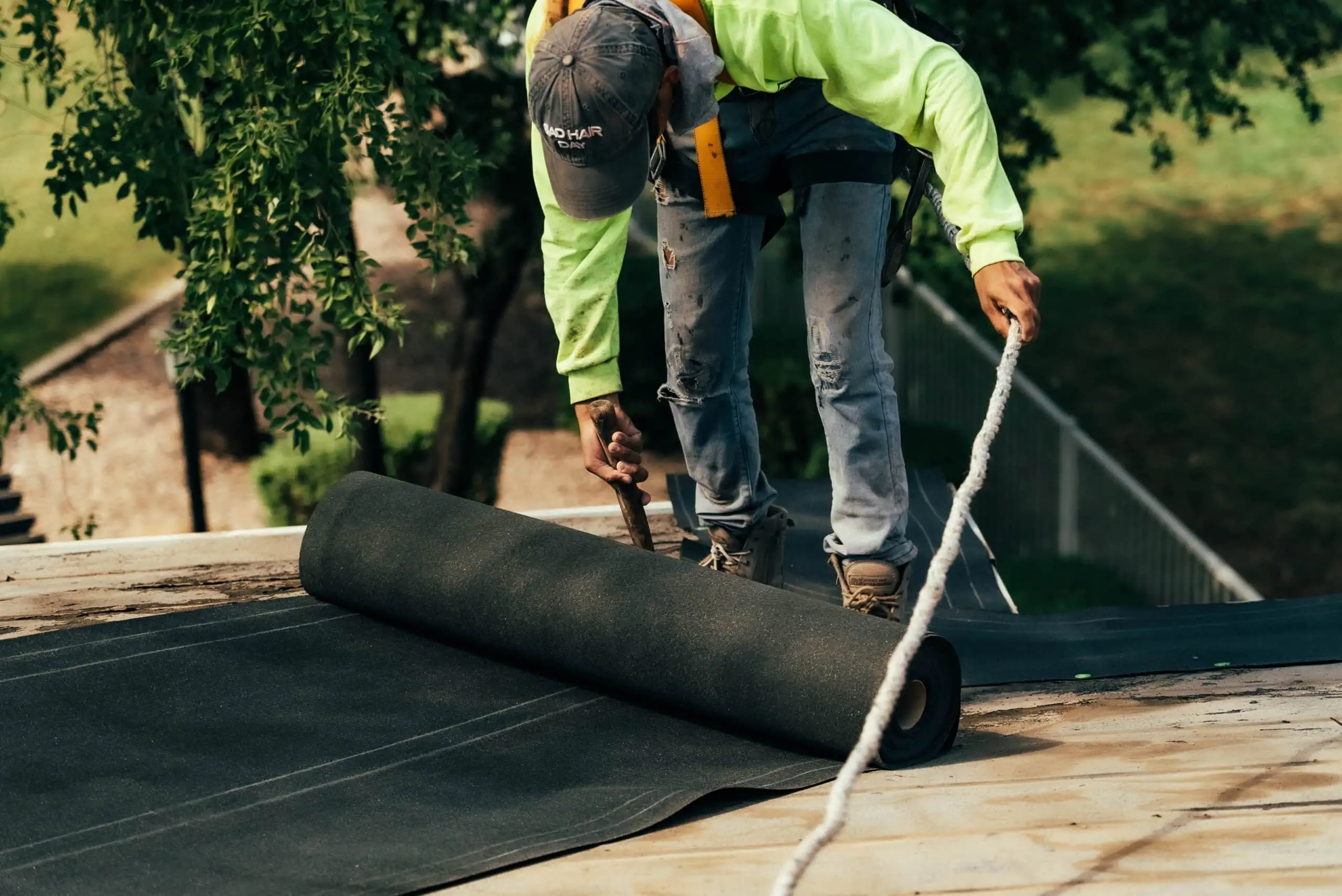 a worker lays underlayment on a roof in peoria az as a part of a roofing project