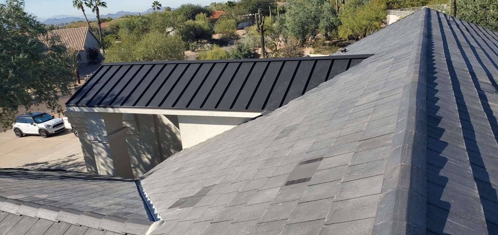 A house with a black metal roof renovated by a Whisper Rock roofing contractor.