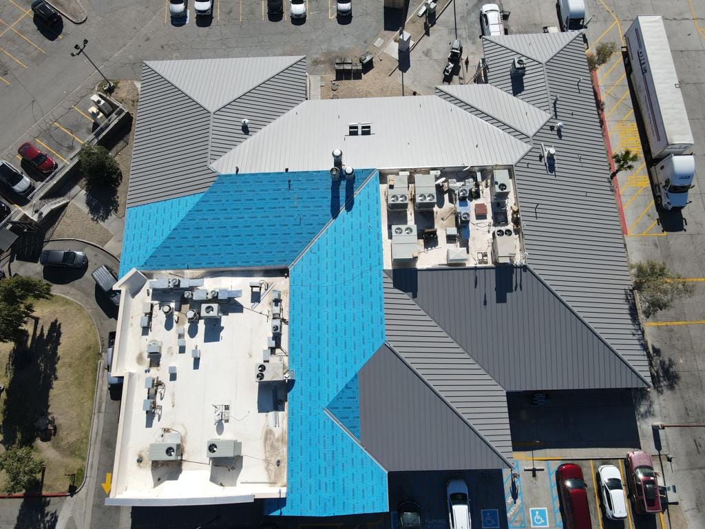 An aerial view of a building with a blue metal roofing.