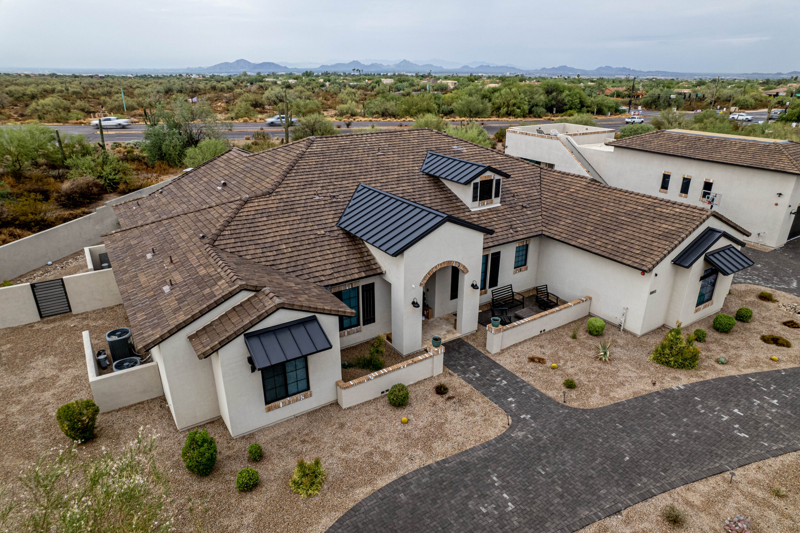 An aerial view of a tiled home in the desert undergoing re-roofing.