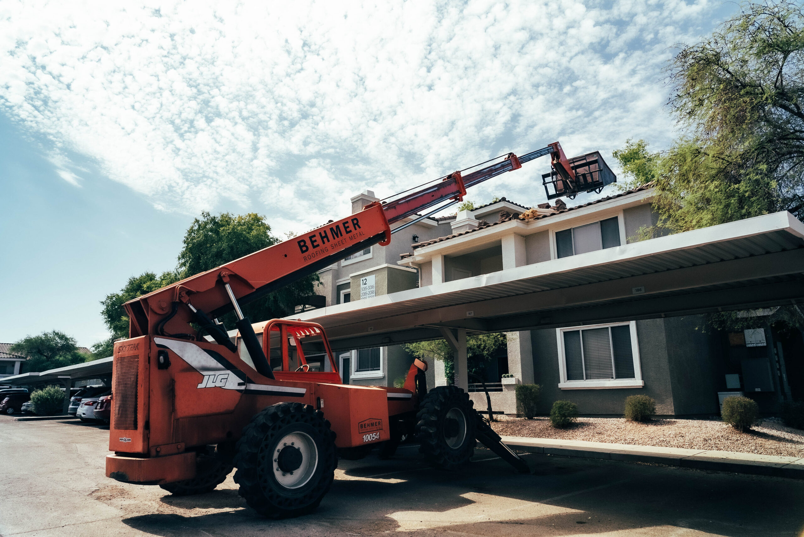A Biltmore Area roofing contractor utilizes a crane to lift a roof in front of an apartment building.