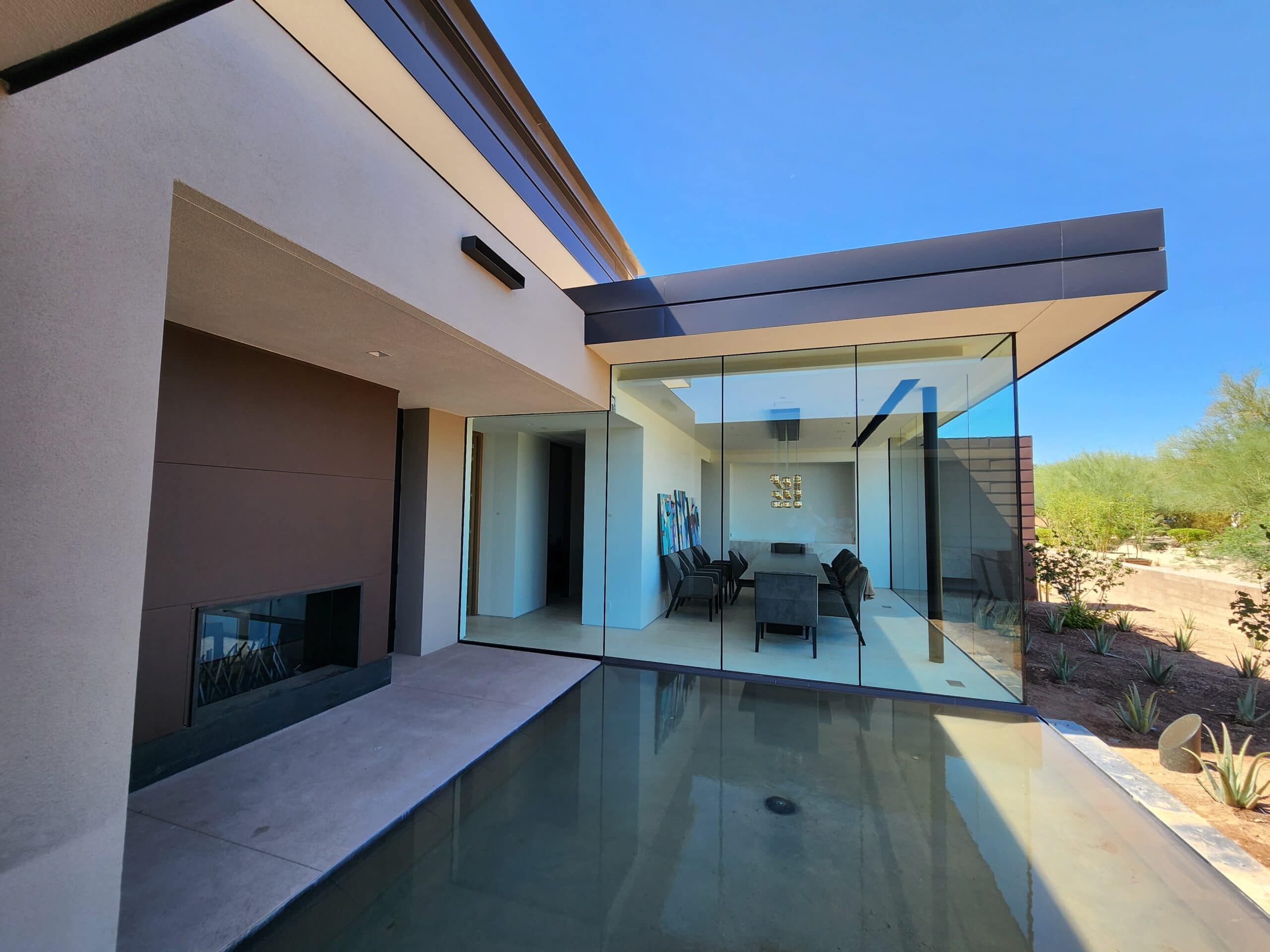 A modern home with glass walls and a pool featuring spray foam roofing for utmost insulation and minimal problems.