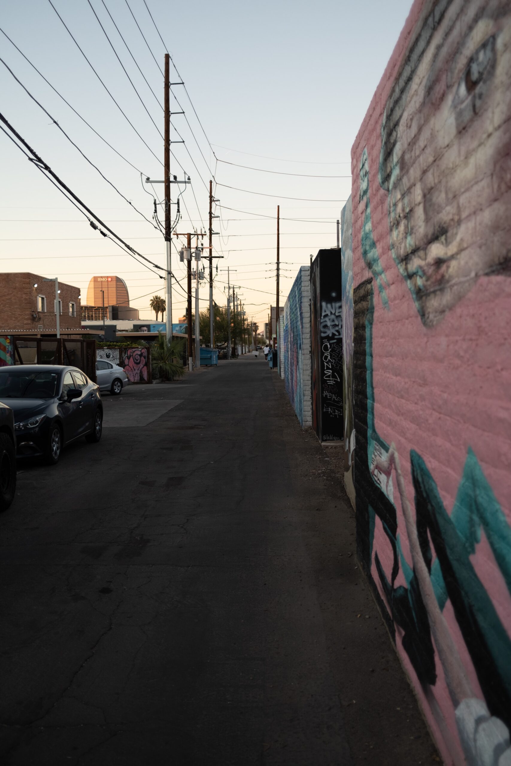 A street with a graffiti-covered wall in North Phoenix near homes that need tile roof installations.