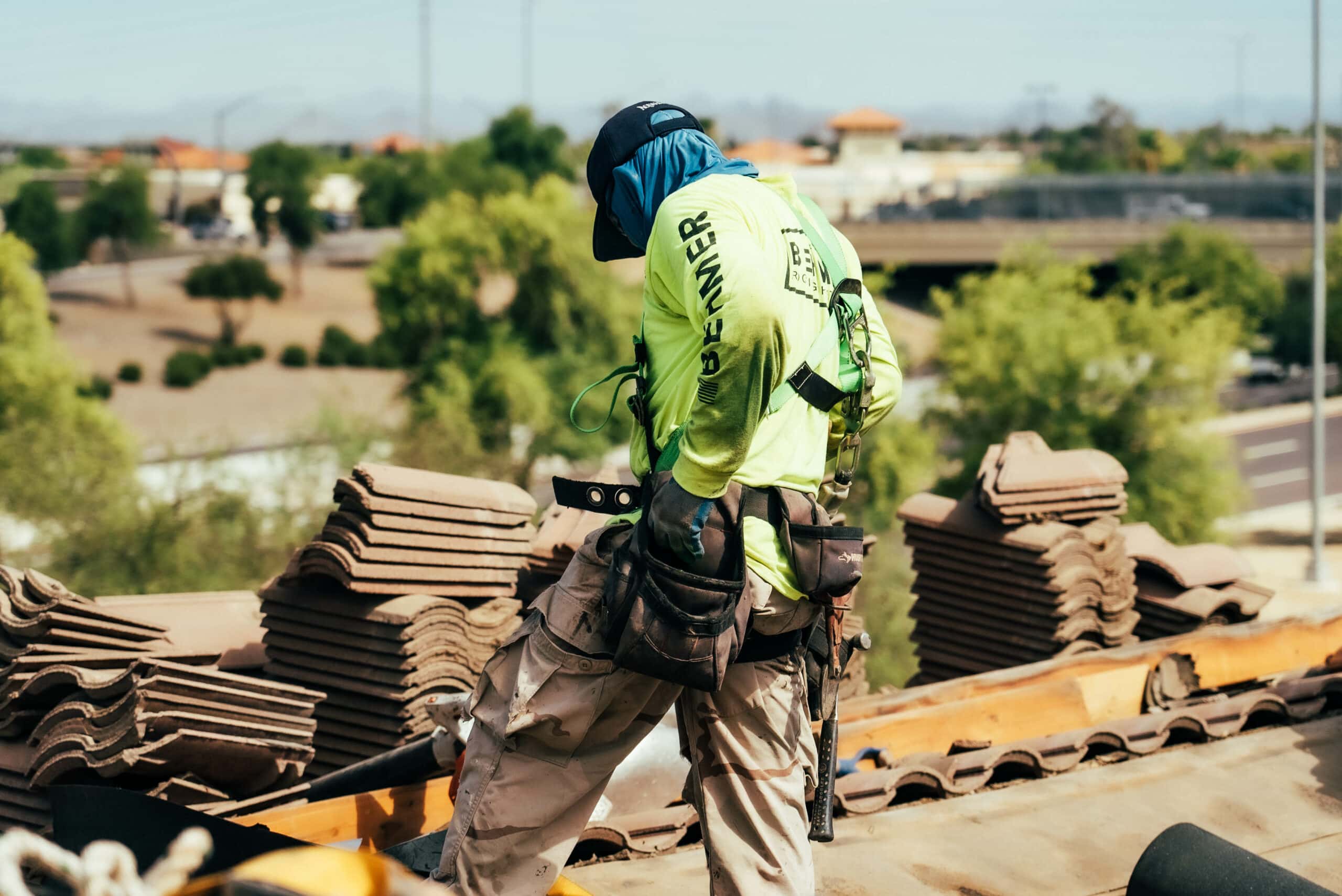 A Behmer Roofing employee is seen performing a tile re-felt in Gilbert, expertly handling each piece with care.