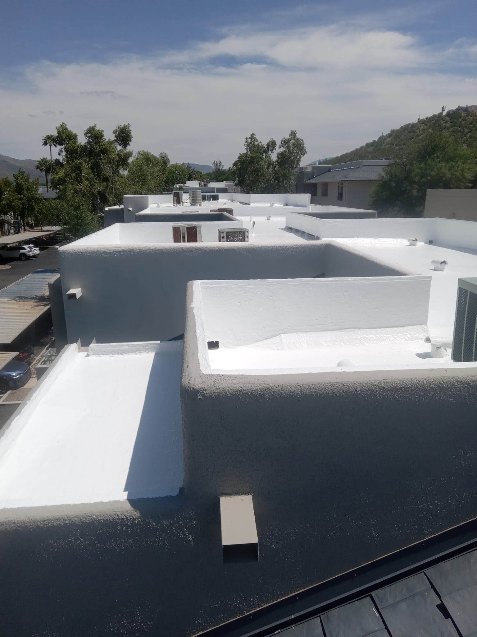 A building with a white roof that has undergone Spray Foam installation.