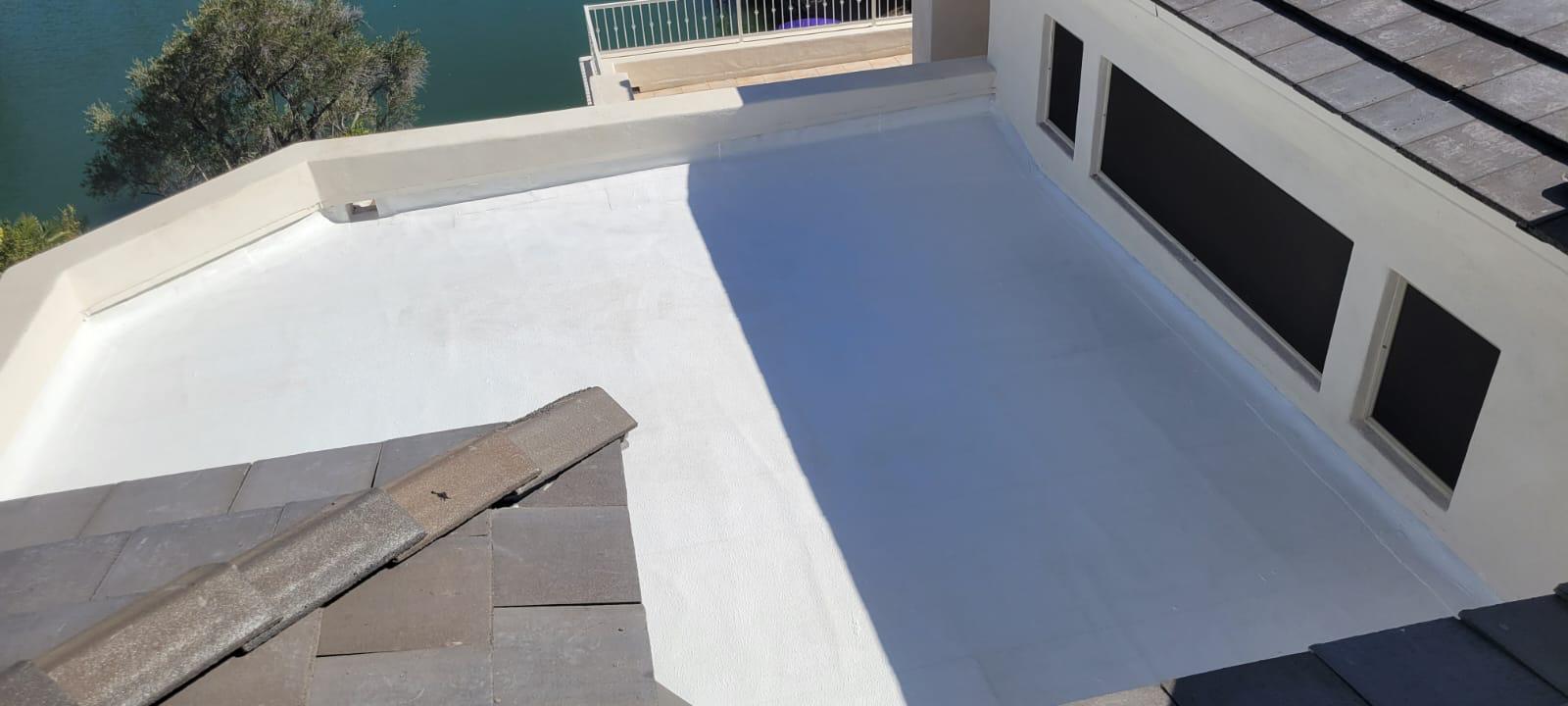 A white roof with a view of a lake, featuring high-quality Spray Foam & Coating Installation in Scottsdale.