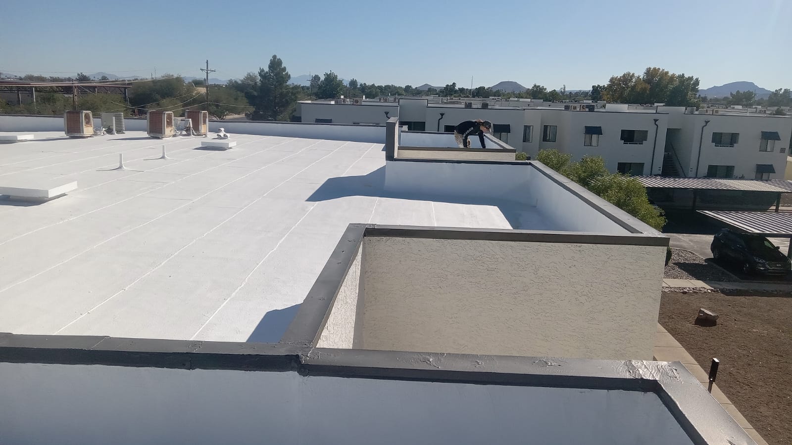 A wide-angle shot of a freshly coated rooftop with spray foam, with Tempe's landscape in the background.