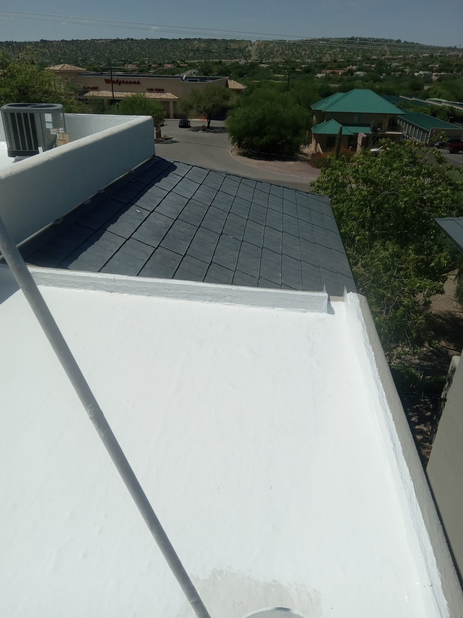 Expert applying protective white coating over spray foam, ensuring durability for this Whisper Rock residential roof.
