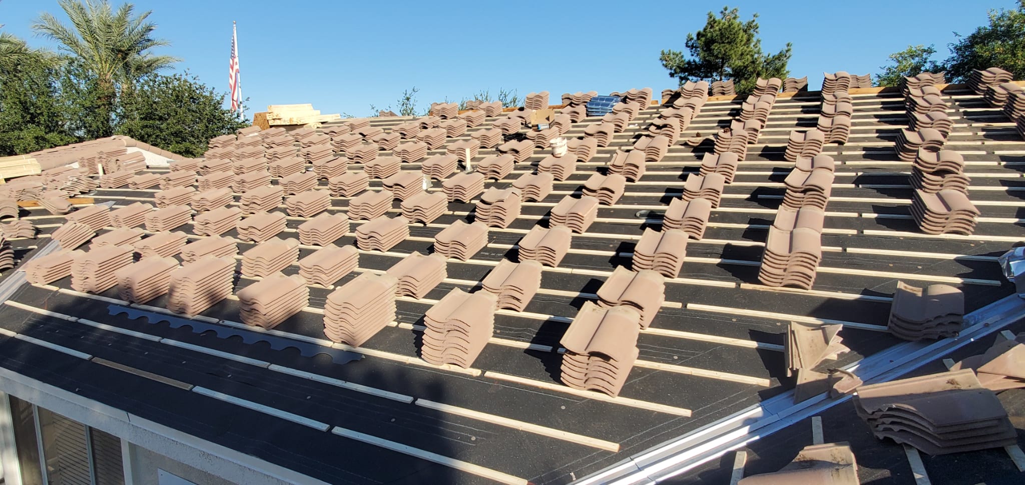 Material tiles neatly arranged on a roof, ready for installation in a Tempe tile roof replacement project.